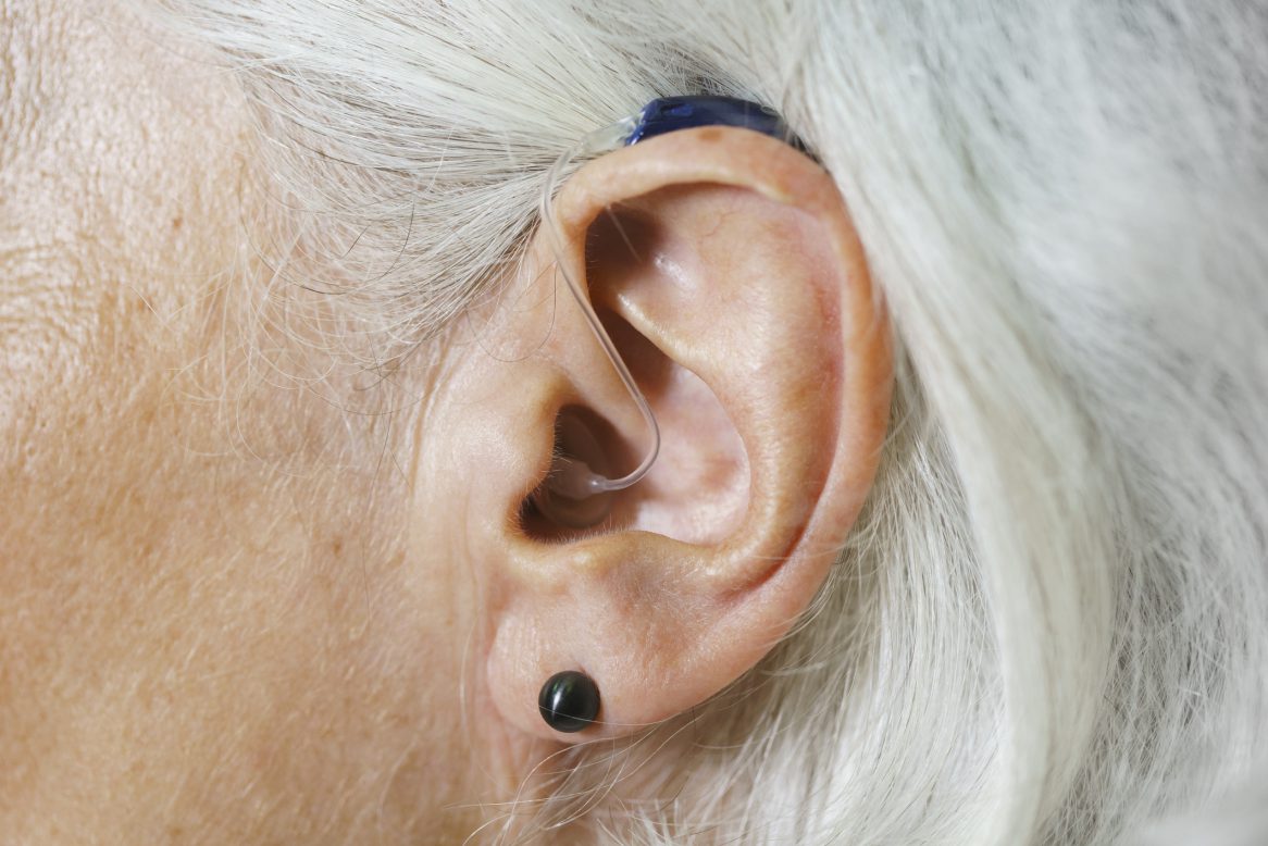 Close Up Of Woman With Gray Hair Wearing Hearing Aid