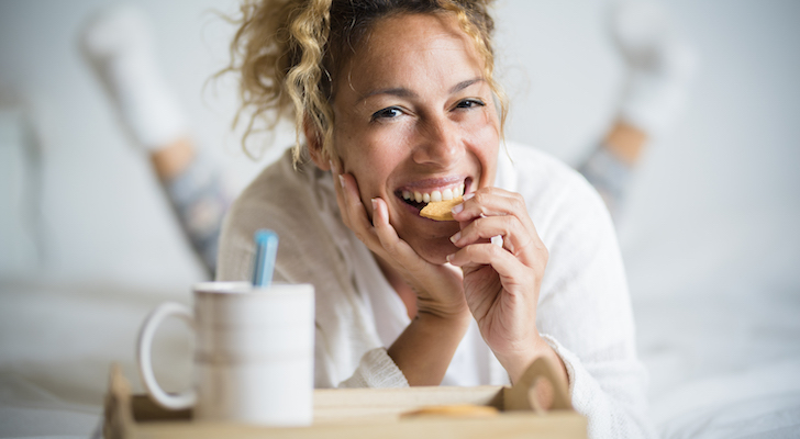 Portrait Of Adult Beautiful Woman Eating Cookie In Morning Breakfast In The Bedroom Home Or Hotel Wake Up Day With Pretty Female People Lay Down With Biscuit And Tea