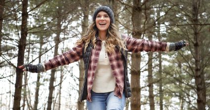 Shot Of A Young Woman Walking On A Tree Log In The Wilderness During Winter