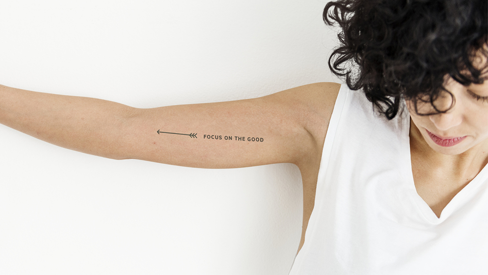 een vrouw toont haar quote tattoo