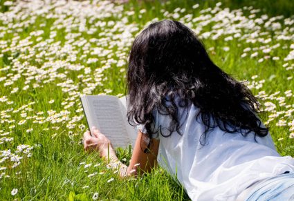 Boeken Lentegevoel: vrouw leest een boek in de weide
