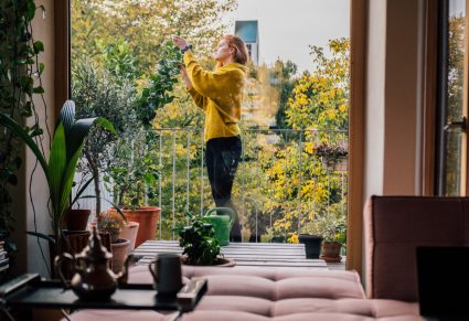 Verticaal Tuinieren: vrouw tuiniert op haar balkon