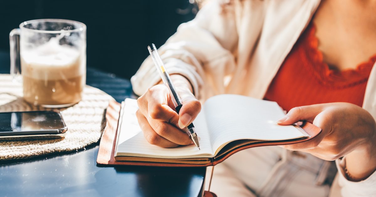 Woman Writing In Her Notebook, Making A To Do List.