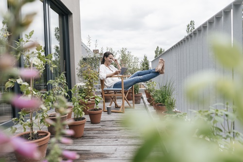 Vrouw zit op klein balkon