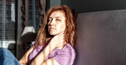A Distraught Woman Sitting On A Bed