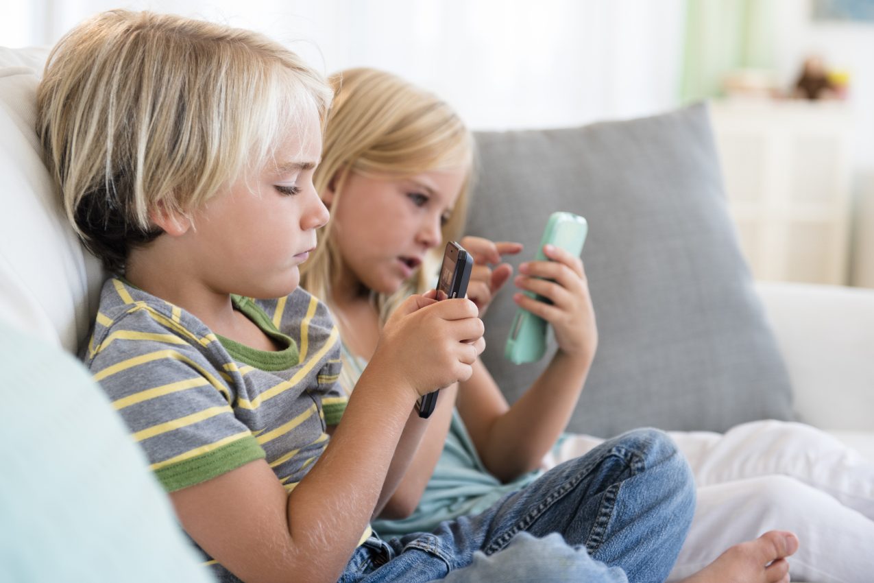 Boy (4 5) And Girl (6 7) Playing Games On Smart Phones