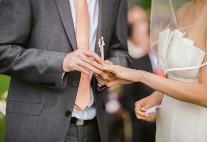 De Juiste Trouwring Kiezen: bruidegom zet trouwring bij bruid