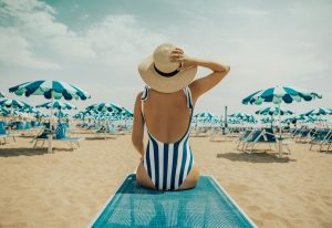 Weg In Augustus: vrouw met hoed op op strand