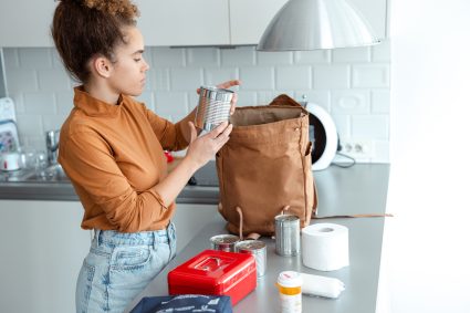 Woman Organizing Emergency Supplies In The Kitchen For Preparedness