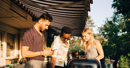 Mensen onder een zonnescherm, bbqen
