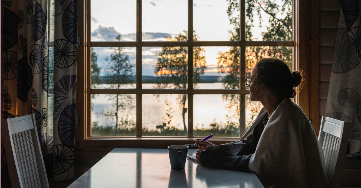 vrouw kijkt uit raam - gelukkig