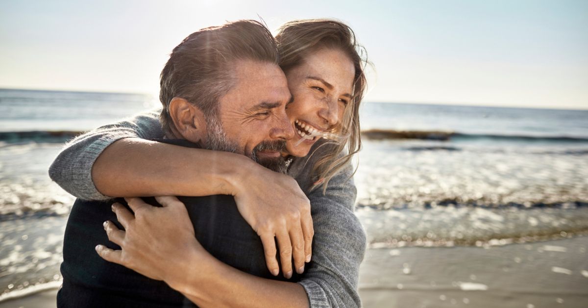 Gelukkig stel, man en vrouw op strand - verlangen