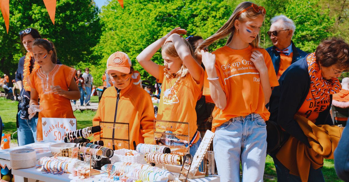 Kinderen verkopen spullen op de vrijmarkt met Koningsdag