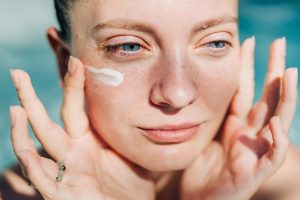 Vrouw met zonnebrandcrème op gezicht